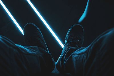 Low section of man in shoes against illuminated lights at night