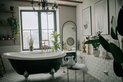 Luxury interior of big bathroom at modern african style with oval bathtub in natural lighting