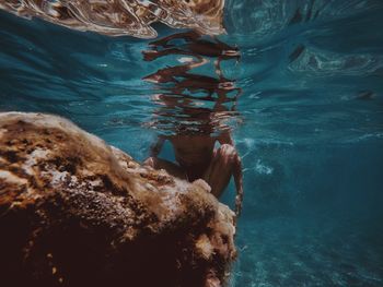 Low section of man on rock in sea