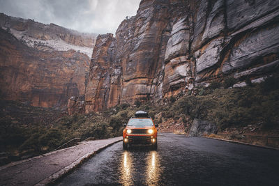 A car is on the rainy road in zion national park, utah