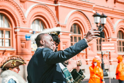 Midsection of man holding woman in city