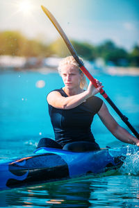 Young woman kayaking on lake