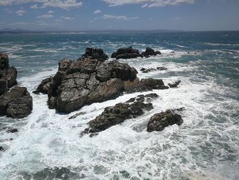 Rock formation on beach against sky