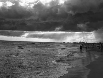 Silhouette man standing on beach against sky