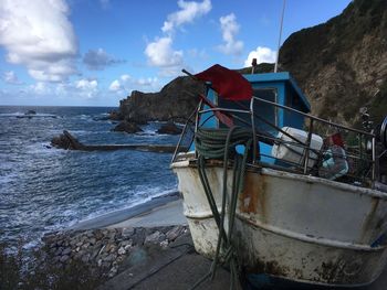 Scenic view of beach against sky and fisher boat 