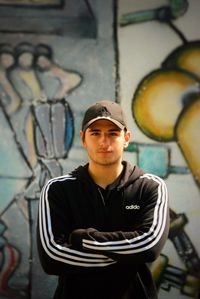 Portrait of young man standing against wall