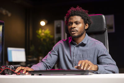 Side view of young man using laptop while sitting at home