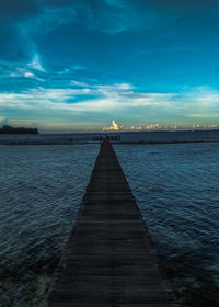 Pier over sea against blue sky