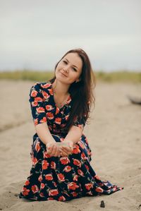 Young woman holding sand on beach