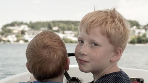 Portrait of boy with brother sitting in boat