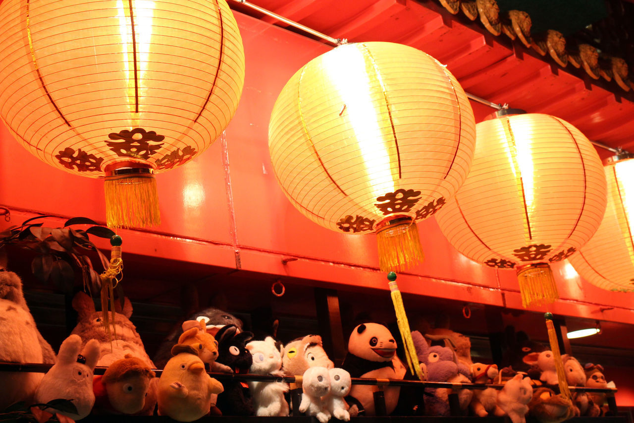 LOW ANGLE VIEW OF ILLUMINATED LANTERNS HANGING IN CEILING