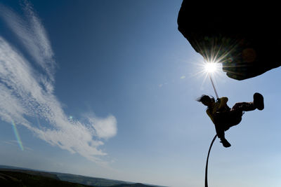Woman rappelling from cliff at windgather rocks in the peak district