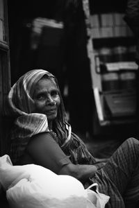 Side view portrait of senior woman sitting by plastic bag