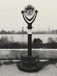 Close-up of coin-operated binoculars against cityscape