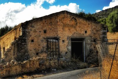 Old abandoned house against sky