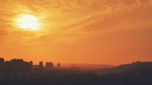 Silhouette buildings against sky during sunset
