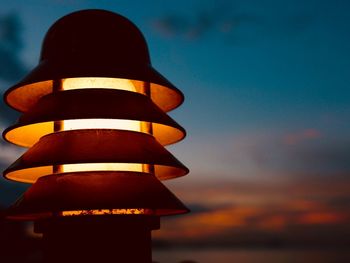 Low angle view of illuminated lamp against sky during sunset