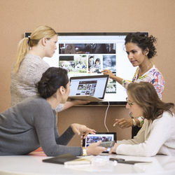 Businesswomen discussing presentation in creative office