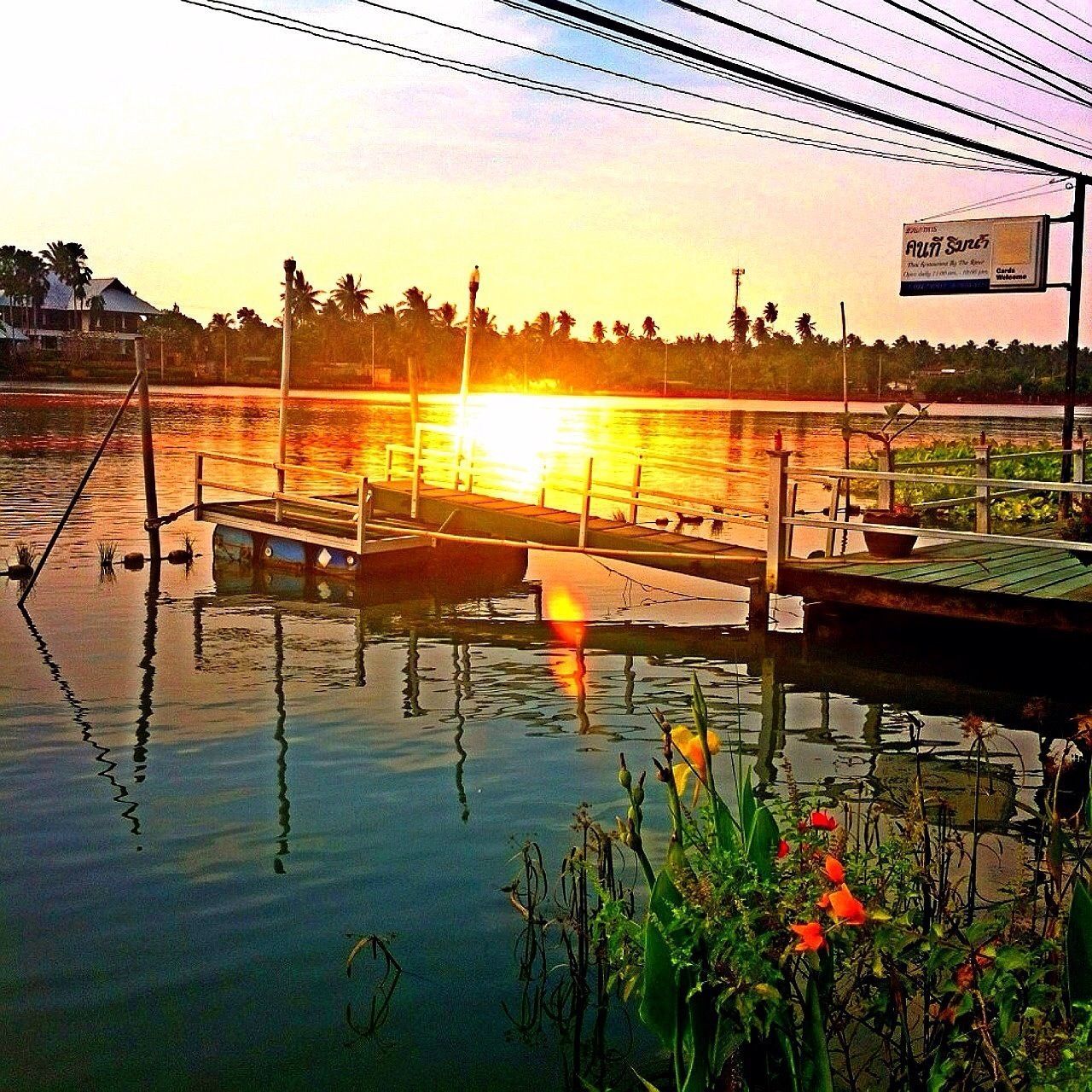 water, built structure, plant, sunset, chair, clear sky, nature, beauty in nature, sunlight, tranquility, architecture, growth, reflection, tranquil scene, no people, sun, lake, flower, outdoors, absence