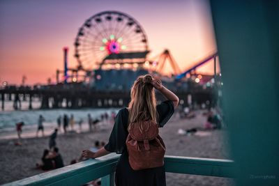 Rear view of woman with ferris wheel in background