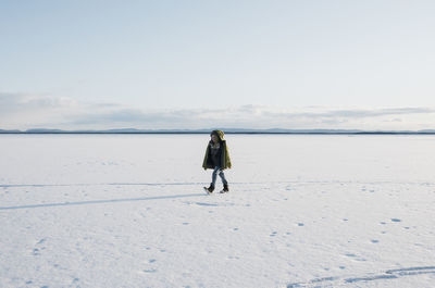 Full length rear view of man on snow covered land