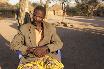 Soba of the muhila tribe sitting on his chair, kehamba, chibia, angola