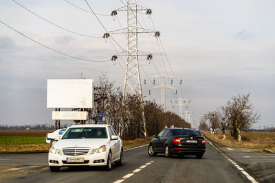 Cars on road against sky in city