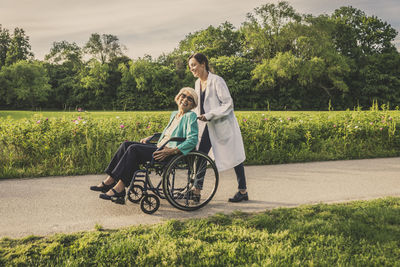 Side view of a couple on field against trees