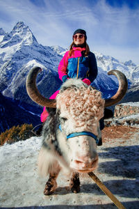 Portrait of mature woman on snowcapped mountains during winter