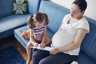 Mother with daughter on sofa