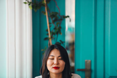 Woman wearing red lipstick against door