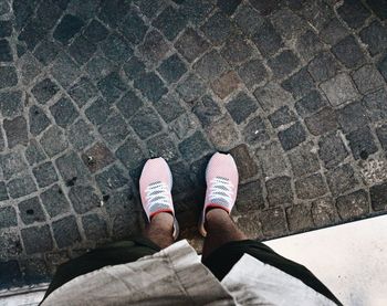 Low section of man standing on paving stone