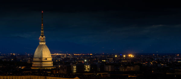 Illuminated cityscape against sky at night