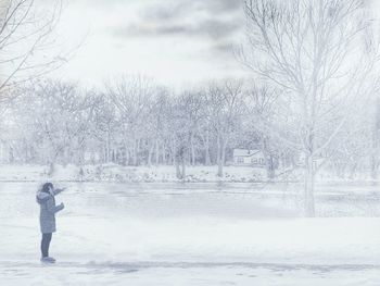 Man on snow covered tree against sky