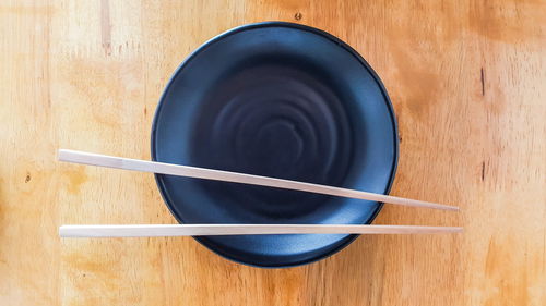 Directly above shot of empty bowl and chopsticks on table