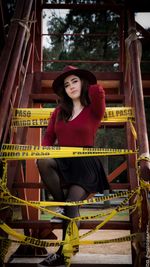 Portrait of woman sitting amidst barricade on staircase