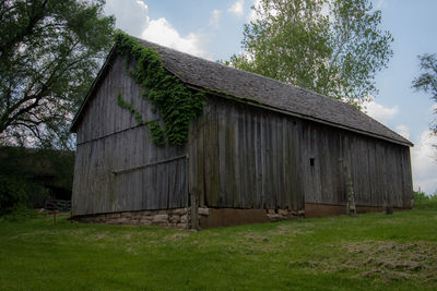 Old house on field against sky