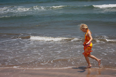 Full length of boy standing on beach