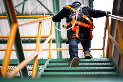 Rear view of man standing on staircase