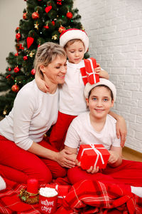 Portrait of happy mother and kids in santa hats. holidays. merry christmas