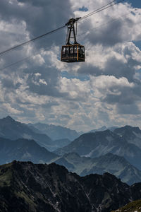 Low angle view of overhead cable car against sky