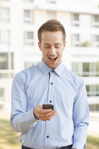 Portrait of smiling man standing on mobile phone