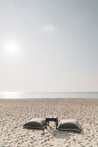 Deck chairs on beach against sky