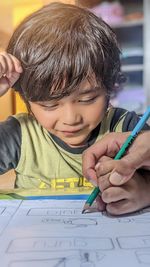 Close-up of boy drawing on book