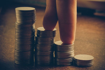 Cropped hand with coins on table