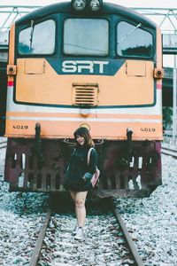 Full length portrait of man standing on railroad track