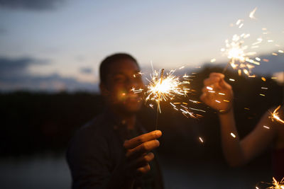 Friends holding sparklers at night