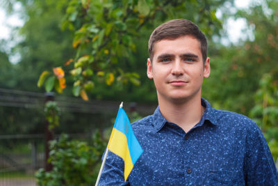 Ukrainian man. young smiling man holding ukrainian flag. no war. support for ukraine. patriotic