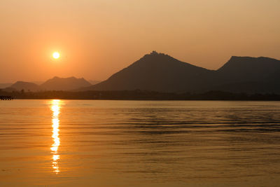 Scenic view of lake against orange sky