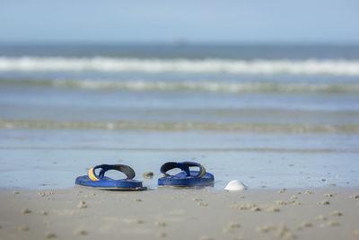 Close-up of shoes on beach